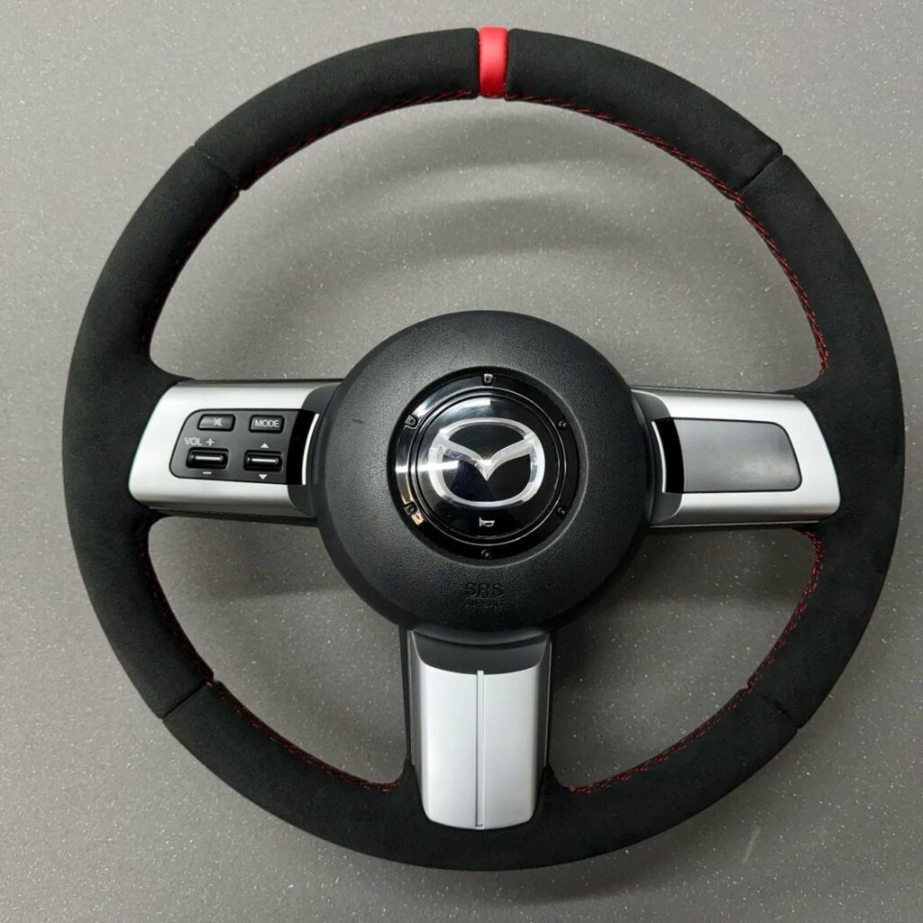 Volan Mazda îmbrăcat în Alcantara, cu cusătură și marcaj central roșu